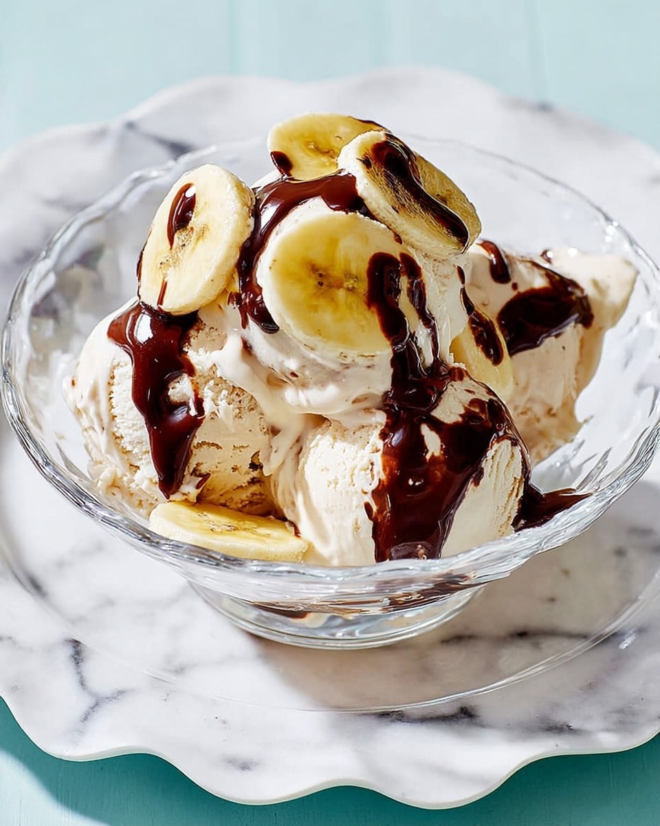 A clear glass bowl with several scoops of creamy light beige ice cream sits on a white plate with a scalloped edge, all placed on a white marbled surface. On top of the ice cream are thick, uneven slices of banana, pale yellow with soft texture, scattered around and partially covering the ice cream. A rich dark chocolate sauce is drizzled generously over the banana slices and ice cream, creating glossy dark brown streaks that contrast with the lighter colors beneath. The glass bowl has vertical ridges adding texture and the whole setup feels fresh and inviting. photo taken with an iphone --ar 4:5 --v 7