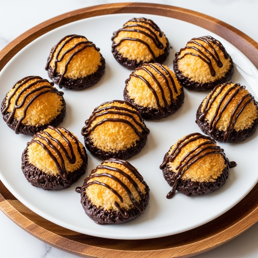 A white textured plate holds ten dome-shaped coconut macaroons arranged in a loose circle. Each macaroon has a golden-brown toasted coconut crust on top with a light and fluffy texture. The bottom of each macaroon is dipped in smooth, dark chocolate, creating a thick coating that spreads unevenly on the plate. Several macaroons are drizzled with three thin stripes of dark chocolate on top, adding contrast to the light coconut. The plate is set on a white marbled surface, with a green cloth partially visible in the background. Photo taken with an iphone --ar 4:5 --v 7
