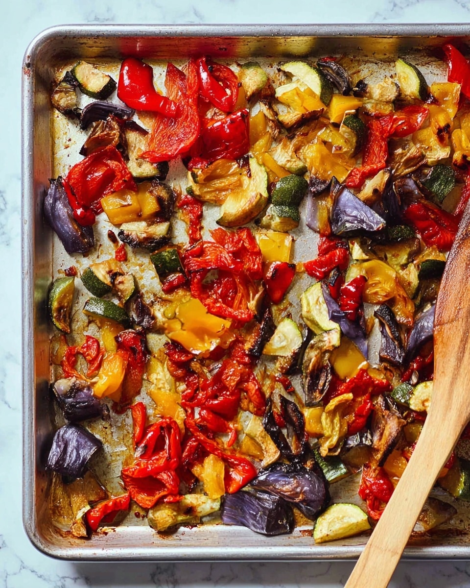 This image shows a silver baking sheet with roasted vegetables spread mostly along the edges, leaving the center mostly empty. The vegetables include chunks of eggplant, red and yellow bell peppers, red onions, and tomatoes. They are cooked to a soft, slightly charred texture, showing a mix of deep purple, bright red, yellow, green, and brown colors. A wooden spatula rests on the lower right corner of the sheet, partly touching the vegetables. The background is a white marbled texture. photo taken with an iphone --ar 4:5 --v 7
