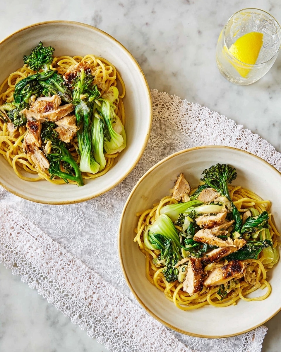 Two bowls of food are shown on a white marbled surface. Each bowl is white and filled with a dish consisting of three main layers: at the bottom, long yellow noodles are loosely piled; on top of the noodles, there are bright green broccoli florets and leafy greens adding texture and color; and scattered above and between the greens are pieces of cooked chicken, light brown with a slight char. One bowl sits directly on the marbled surface, while the other is placed on a white cloth with lace edges. In the top right corner, there is a glass of water with lemon slices. Photo taken with an iphone --ar 4:5 --v 7
